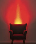 Plug In Wall Sconce Uplighter With GU10 Spotlight Wash Light casting warm red glow behind armchair