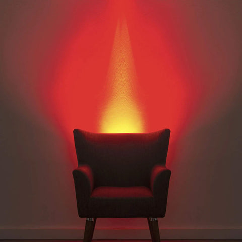 Plug In Wall Sconce Uplighter With GU10 Spotlight Wash Light casting warm red glow behind armchair