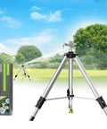Tripod Base Brass Impact Sprinkler With Pulsating 360 Degree Coverage set up in a lawn with extended spray, box packaging shown
