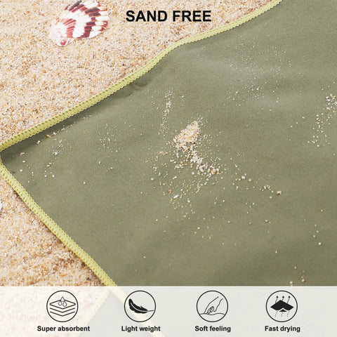 Ultra Compact Microfiber Towel For Travel, Gym, And Camping on sand, showing sand-free surface with shell nearby.