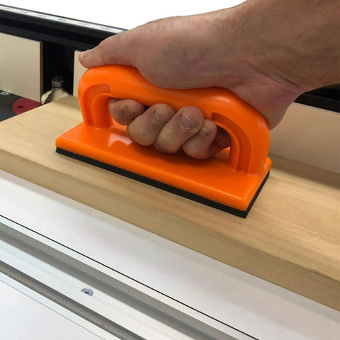 Heavy Duty Five Piece Woodworking Safety Kit With Beefy Push Blocks And Grippy Push Sticks To Keep Your Digits Well Clear From Nasty Kickback On Table Saws And Routers, showing orange push block in use on wood.