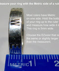 A silver ring resting on a blue metric ruler, demonstrating measurement for EZsizer selection, with text instructions visible.
