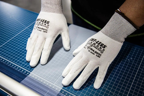 Cut Less Dyneema Gloves With Grippy Polyurethane Palm 1 Dozen SM13 Gauge Liner ANSI A3 ultra lightweight on blue grid surface