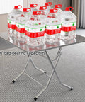 Ultra Strong Stainless Steel Folding Work Table With Thick Silicone Floor Pads And Premium Brushed Finish X Beam Reinforcement For No Sweat Garage Or Backyard Projects holding multiple water containers.