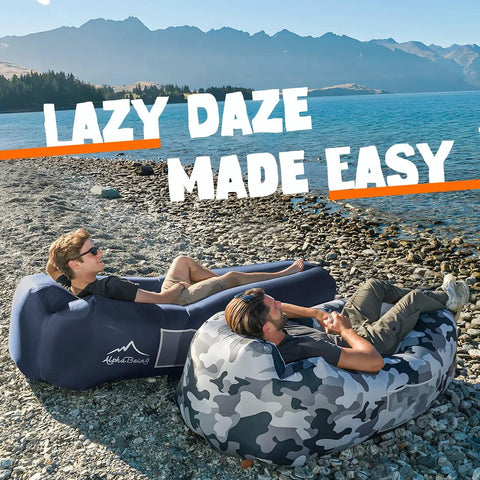 Two men relax on Inflatable Lounger Beach Chair With Air Sofa Hammock For Camping And Backyard Hangout on a lakeside beach.