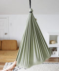 Ultimate Chill Cotton Sensory Cocoon Swing For Kids Autism And ADHD Therapy Support Indoor Outdoor Hammock Desert Sage hanging in a room.