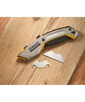 Gray 2 In 1 Snap Off Knife Xtreme with stainless steel blade guide on wooden surface, extra blades beside.
