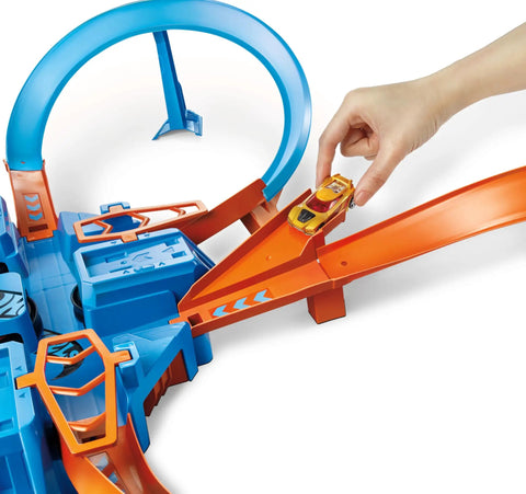 Hand placing car on Hot Wheels Criss Cross Crash Track Set With 1 To 64 Scale Car Four Intersections Motorized Booster Power Epic High Speed Crashes And Car Feeder Ramp Amazon Exclusive Toy For Kids