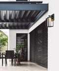 Modern porch with Capulet Amber Glass Center Column Outdoor Indoor Wall Sconce With LED Black Finish, minimalist design.