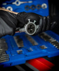 Hands using Beast 110 Piece Metric Tap And Die Set For Threading Bolts And Pipes, focus on die tool with blue case background.