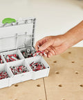 Person picking an anchor from Festool DuoPower Anchor Set 5 6 8 10 Mm With 6 x 35 Chipboard Anchors in MINI Systainer S 76