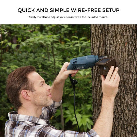 Person installing Half Mile Solar Powered Wireless Driveway Alarm With Motion Sensor on tree