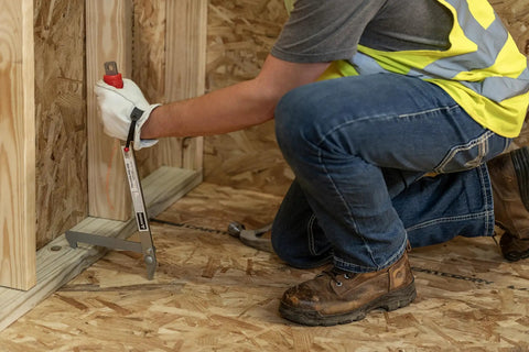 Person using Little PeeVee Sill Plate Tool for construction walls, 18 inch length steel puller, ergonomic grip, nailing aid for precision.