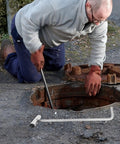 Person using Heavy Duty Stainless Steel Manhole Cover Hook With Sturdy T Shaped Handle Design For Dead Simple Storm Drain Grate Lifting.