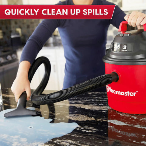 Pro Grade 2.5 Gallon Wet Dry Shop Vac Featuring Wall Mount Storage And Killer Suction Motor For Rapid Garage Sweeps Durable Carry Handle Design In Fiery Red used to clean spills on a granite countertop.