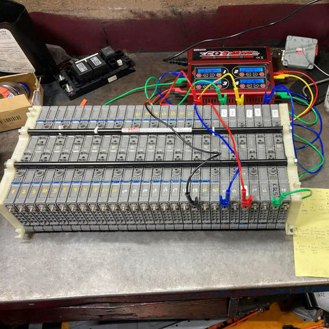 Automotive diagnostic wires connected to a car battery pack for testing and troubleshooting purposes
