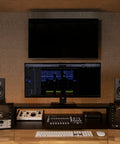 Studio desk with MR4 Powered Studio Monitor Speakers, 4 Inch Active Near Field Reference Monitors in black next to a computer setup.