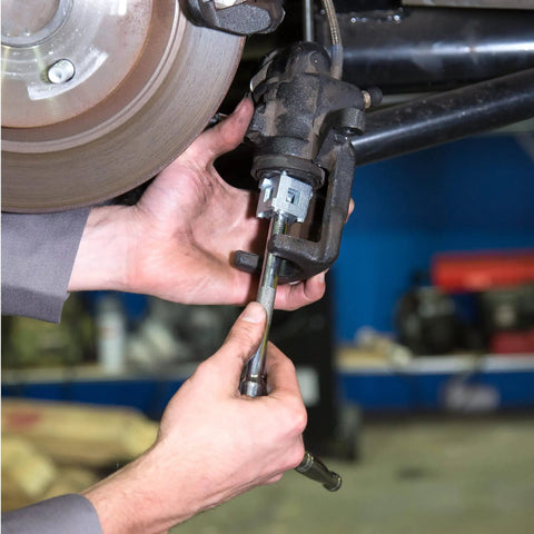 Mechanic using Rear Disc Brake Piston Tool And Caliper Compression Tool For Easy Brake Pad Change And Caliper Service With Three Eighths Inch Drive And Pro Grade Forged Steel Build For Most Cars And Light Trucks on a vehicle