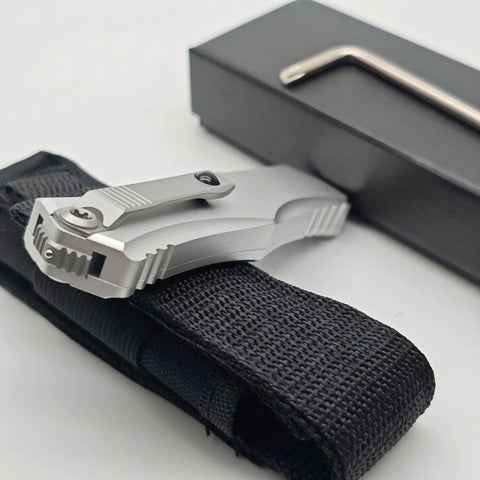 Rugged folding knife with belt clip for camping and outdoor gear, aluminum alloy T6063 handle, folded and placed on black case