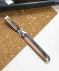 No-Tear Push-Style Staple Remover With All-Metal Chrome Construction, shown on cork surface with scissors in view