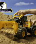 Child playing with Steel Front Loader Toy Truck for Kids Ages 3 and up, built tough with a steel frame, scooping sand outdoors.