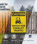 Built Like A Tank Heavy Duty Caution Watch For Forklift Traffic Safety Sign Rust Resistant Outdoor Aluminum Warning Plaque Easy Screw Mounting on display in harsh conditions.