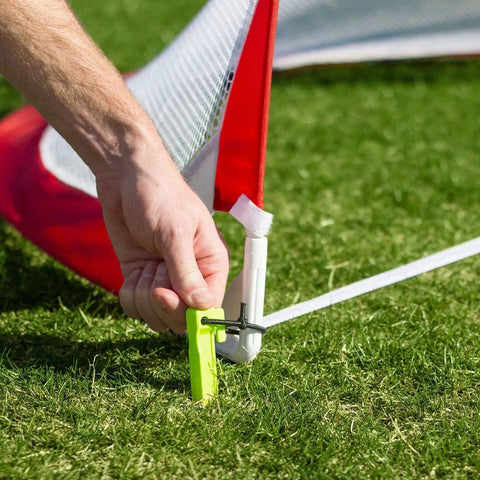 Portable Pop Up Soccer Goals For Backyard Set Of Two 4 Foot Nets being staked into the ground for stability