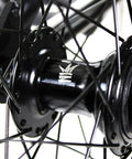 Close-up of BMX freestyle bike with durable steel frame in white, available in 16, 18, 20, 26, and 29 inch sizes, black hub detail