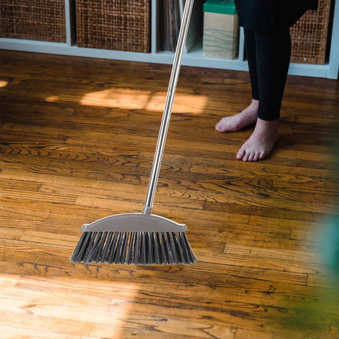 Dark Grey Angle Floor Broom With Long Stainless Steel Handle And Dense Stiff Bristles snags pet hair on hardwood floor.