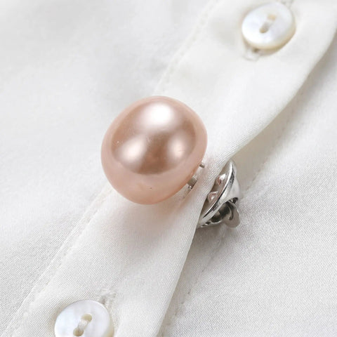 Close-up of a pink faux pearl brooch pin on a white shirt, part of 25Pcs No Sew Faux Pearl Brooch Pins Detachable Sweater Clips Reusable Shirt Fasteners Your New Go To Wardrobe Lifesaver For Hassle Free Snug Security On Every Fit You Own.
