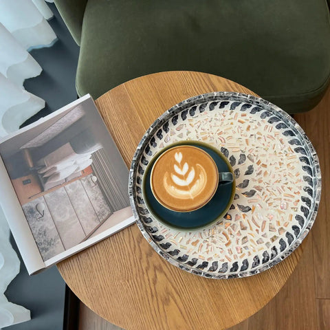 12 Inch Wooden Lazy Susan With Mother Of Pearl Inlay Smooth Spinning Turntable Serving Tray with a coffee cup on a wooden table.