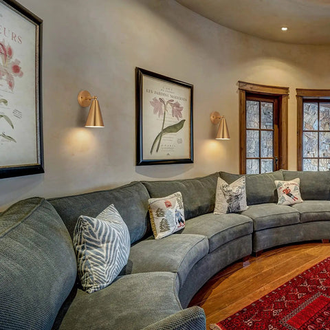 Gold Brass Wall Sconces Set Of 2 With Dope Adjustable Swing Arm Lamps and Metal Shades in living room with sofas and art.