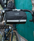 Everywhere Handlebar Bag 5L Rigid Front Barrel Pack with Foam Spacer Kit mounted on bike handlebars, showing carrying handle and reflective trim.