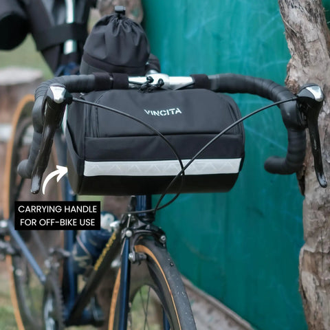 Everywhere Handlebar Bag 5L Rigid Front Barrel Pack with Foam Spacer Kit mounted on bike handlebars, showing carrying handle and reflective trim.