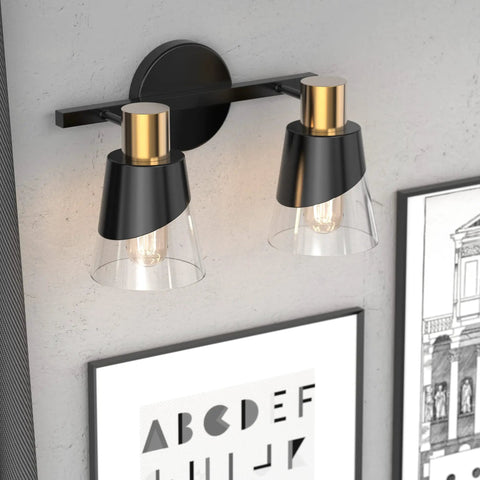 Over Mirror Vanity Light Fixture With Black And Gold Finish 2 Light Wall Lamp with beveled edge clear glass shades mounted on wall.