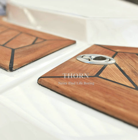Close-up of Thorn 2-inch stainless steel flush pull slam latch installed on wood-grain boat hatch panels.