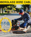 Worker using Beefy Heavy Duty Fiberglass Duct Rodder 8mm by 150m 492ft with wheel stand near pipeline access