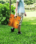Person holding Portable Wine Picnic Table in Acacia Wood With Larger Foldable Tray Charcuterie Board Surface on grass