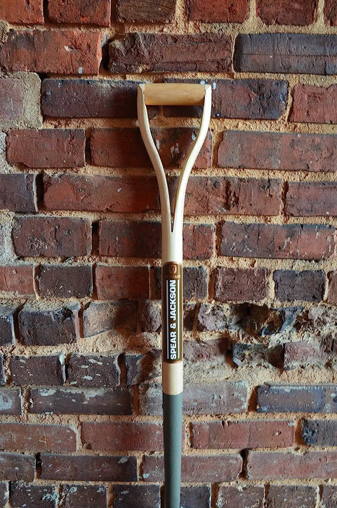 Heritage Forged Digging Fork With Solid Carbon Steel Head And Wishbone Handle against brick wall