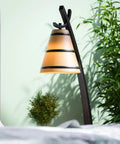 Wright 1 Light Table Lamp in Oil Rubbed Bronze Finish with amber shade in home office setup with plants, cozy lighting.