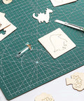 Knife blade and drive housing for Maker 3, metal silver tool on green cutting mat