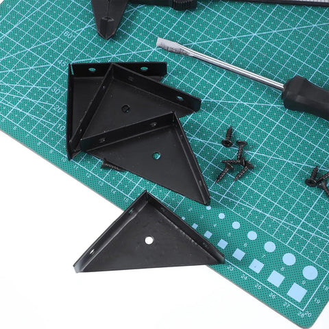 Four Pack Corner Brackets 66mm by 66mm right angle shelf braces with screws on a green cutting mat