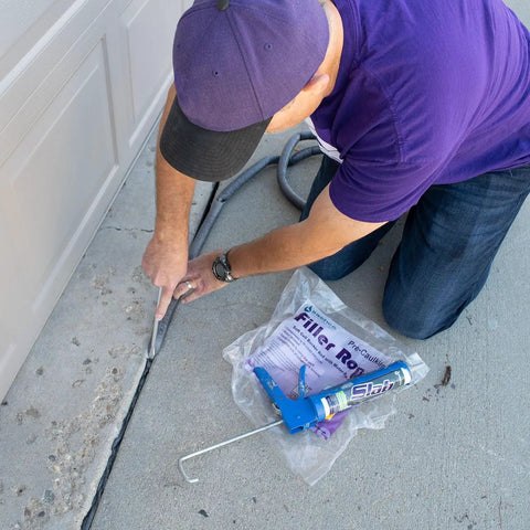 Person applying Elastic Slab Concrete Crack Repair Sealant Gray 10.5 Ounce Cartridge Pack Of Twelve to concrete driveway crack