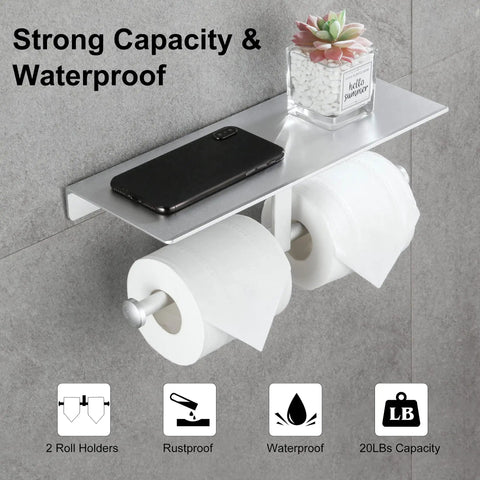 Anti Rust Aluminum Double Roll Toilet Paper Holder with Built In Shelf for Phone Keys and Essentials Self Adhesive or Screw Mount No Drill Bathroom Organizer in Silver Finish, installed on wall with phone and plant on shelf.