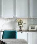 Modern kitchen with 10 Pack Black Round Cabinet Knobs on white cabinets, 1-1/5 Inch Single Hole Pulls for easy installation.