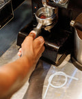 Barista using espresso machine with Six Pack Milk Frother Hose Replacement Kit With Three Connectors for Espresso Machines visible.