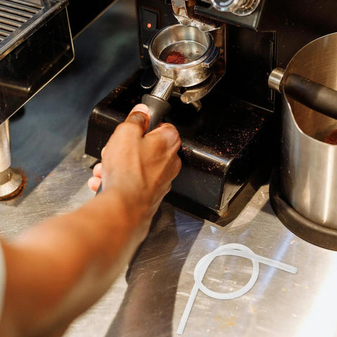 Barista using espresso machine with Six Pack Milk Frother Hose Replacement Kit With Three Connectors for Espresso Machines visible.