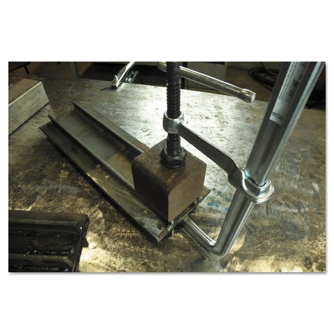 Beefy 12 Inch All Steel Bar Clamp With 2660 Nominal Clamping Force on metal workbench, heat treated for max strength.
