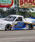Racing truck on track with Nitro Lubricants branding and sponsors, showcasing automotive performance applications of the product.