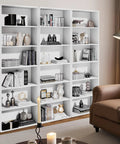 Tall 71 Inch White Bookshelf With Six Open Shelves Floor Standing Bookcase For Living Room Home Office And Bedroom Super Sized Storage For Books Decor And More, filled with books and decor items against a beige wall.